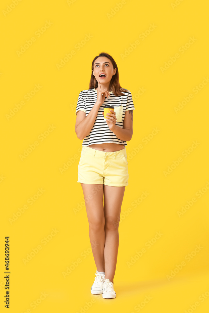 Thoughtful woman with cup of coffee on color background