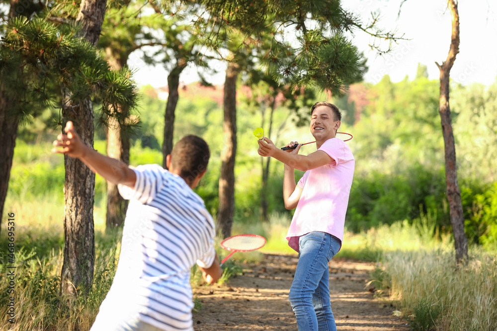 Young men playing badminton  outdoors