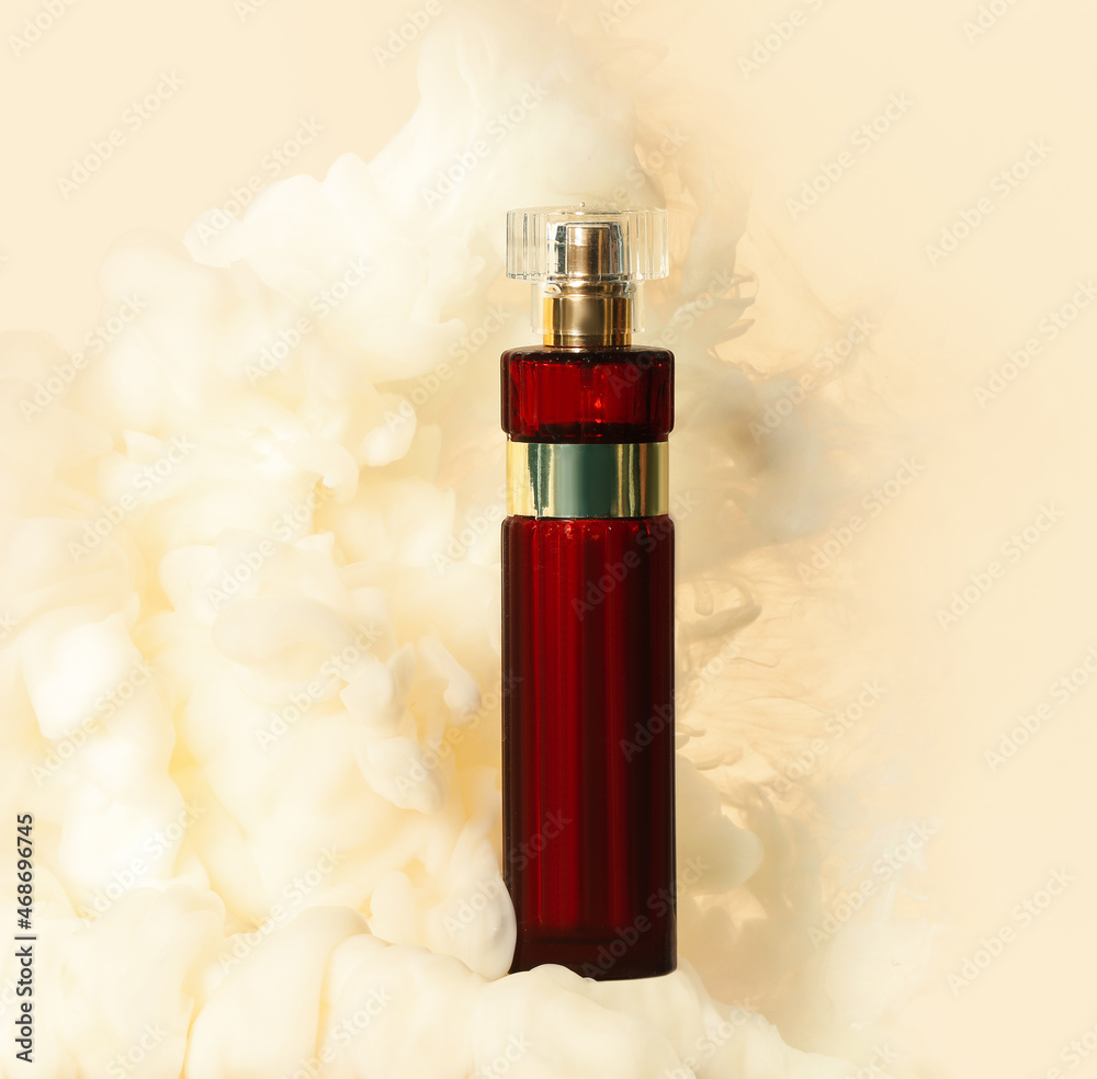 Perfume bottle in light smoke on beige background