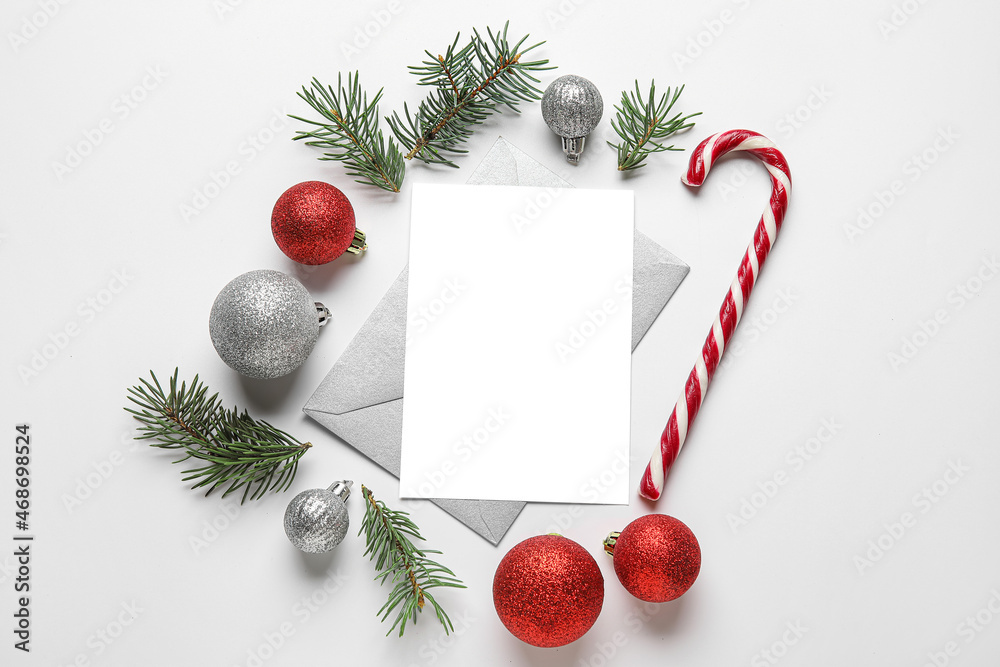 Blank card, fir tree branches, Christmas balls and candy stick on white background