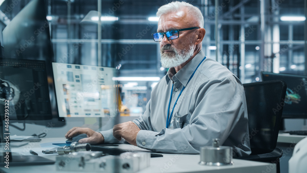 Car Factory Office: Portrait of Senior Male Chief Engineer Working on Desktop Computer in Automated 