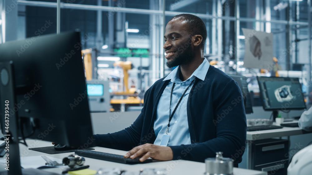 Car Factory Office: Portrait of Confident Black Male Chief Engineer Working on Desktop Computer. Pro