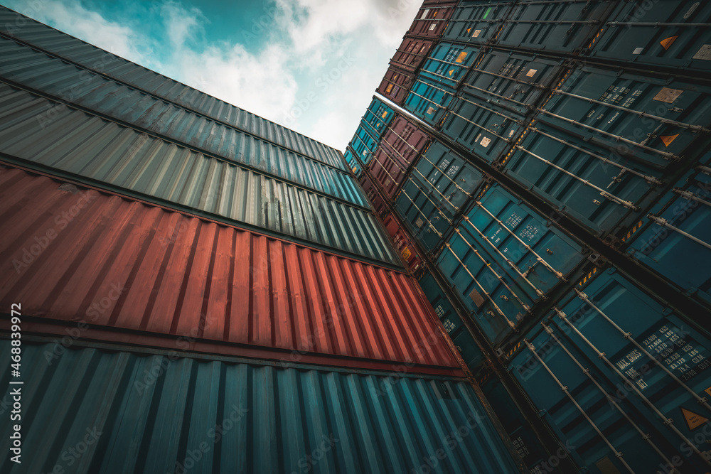 Cargo container for overseas shipping on high stack look up from ground . Logistics supply chain man