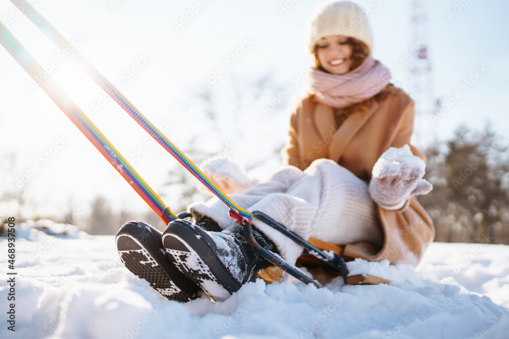 Happy woman  rolls  on a sled in the winter snowy forest. Сouple having fun in the winter nature. Ho