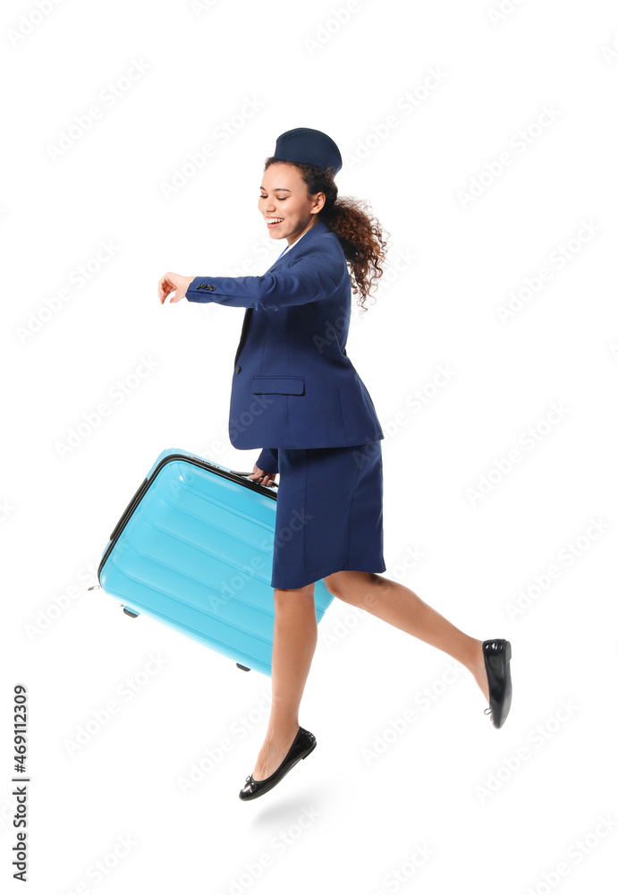 Jumping African-American stewardess with suitcase on white background