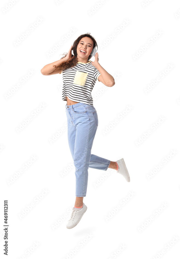 Jumping young African-American woman with headphones on white background