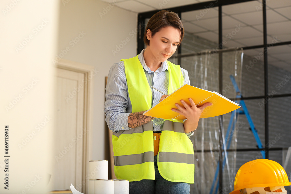 Female construction worker with folder in room