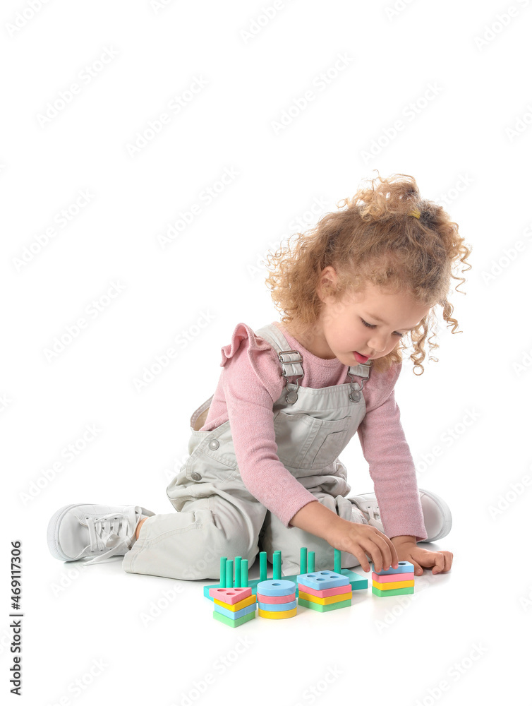 Cute baby girl playing with toys on white background