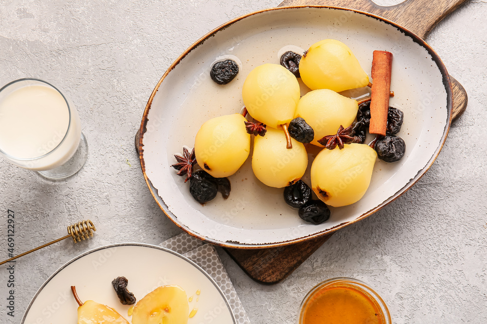 Dish with poached pears, prunes, anise and cinnamon on light table