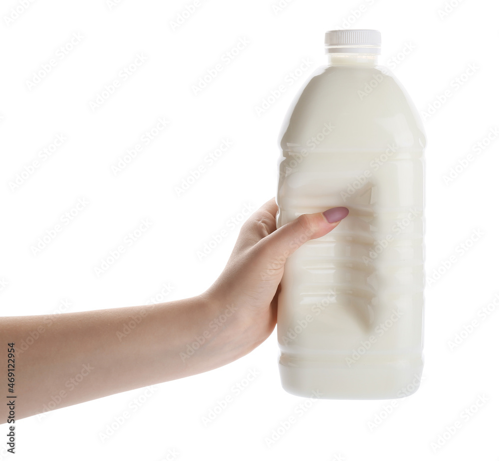 Female hand with gallon bottle of milk on white background