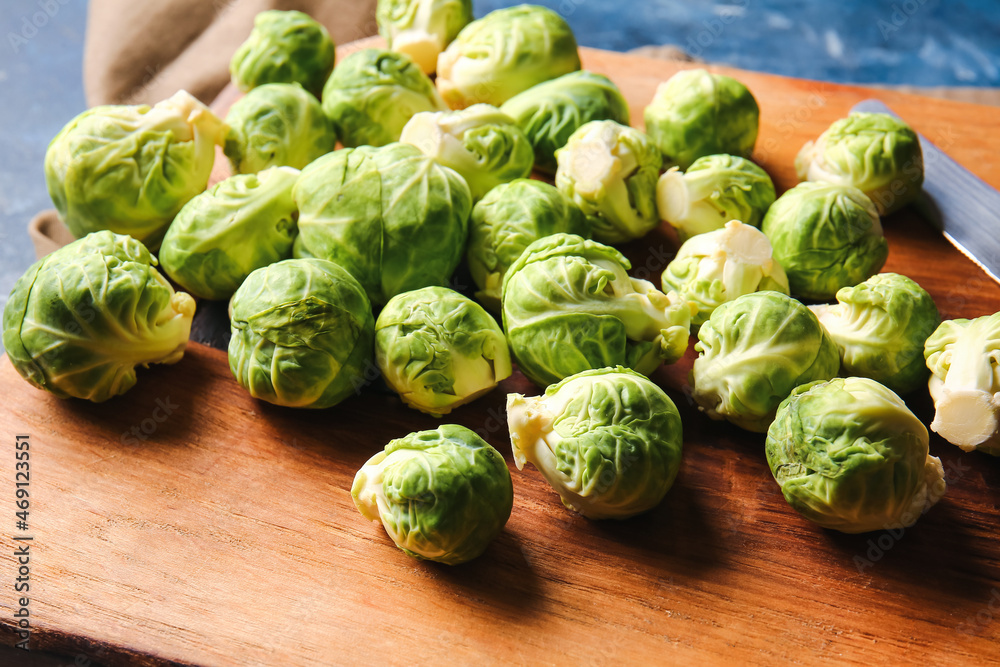 Board with raw Brussels cabbage on table, closeup