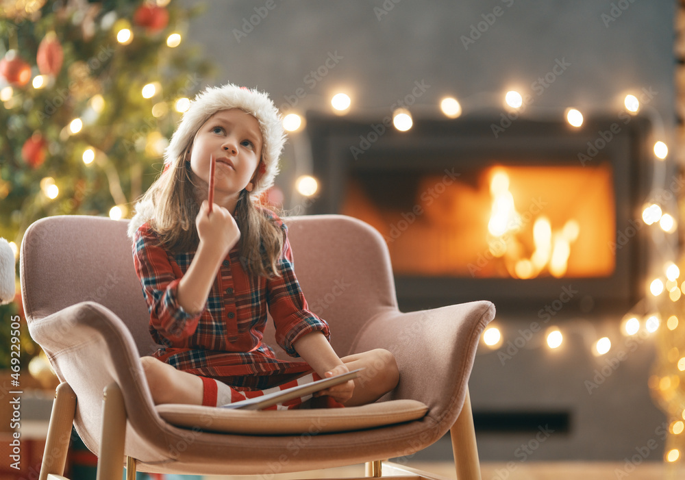 girl is writing the letter to Santa