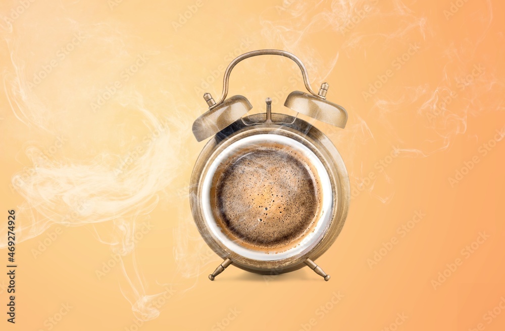 Steamy coffee drink. Hot coffee inside of alarm clock as a symbol of coffee time.