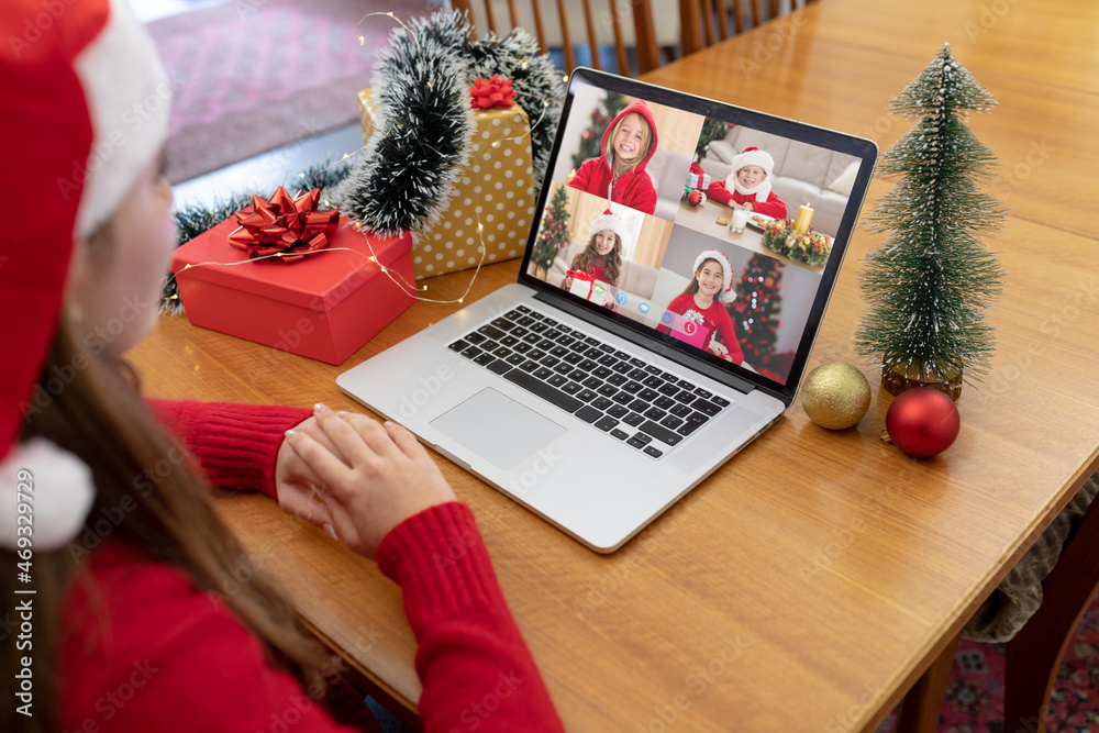 Caucasian woman in santa hat making laptop christmas group video call with four caucasian girls