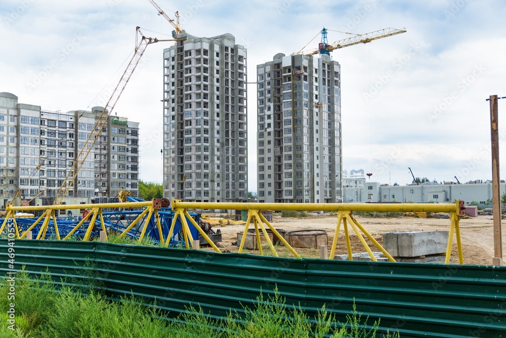 大型建筑工地，包括在建筑群上工作的几台起重机，天空晴朗