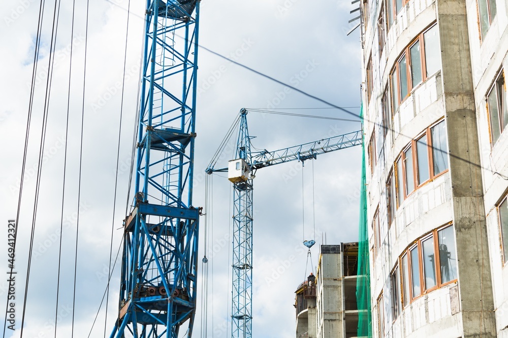 大型建筑工地，包括在建筑群上工作的几台起重机，天空晴朗