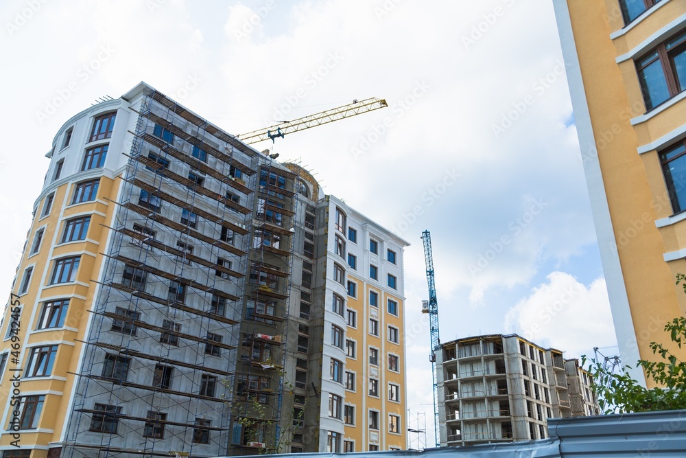 大型建筑工地，包括在建筑群上工作的几台起重机，天空晴朗