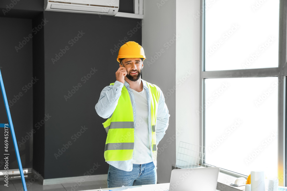 男建筑工人在房间里用手机聊天