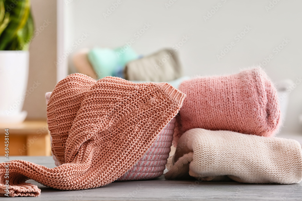 Clean clothes and basket on table in room, closeup