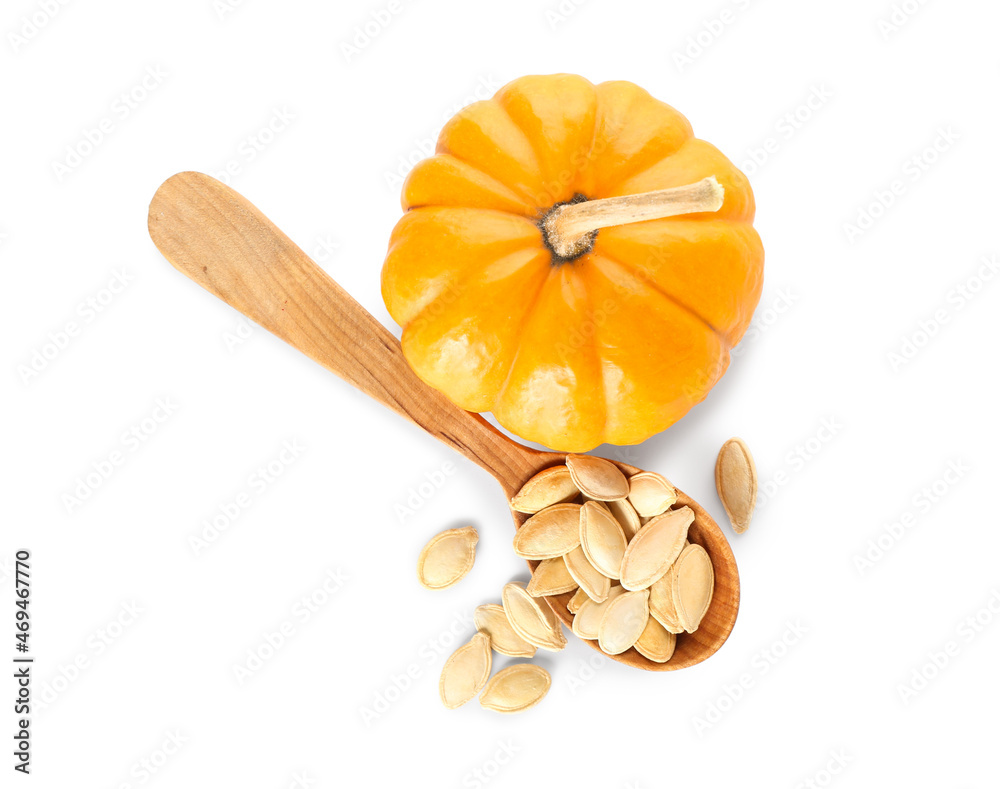 Spoon with pumpkin seeds on white background