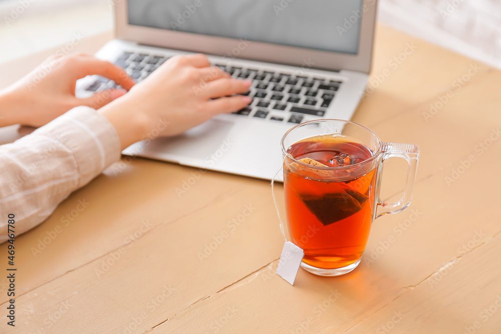 Glass cup of hot tea on table in cafe