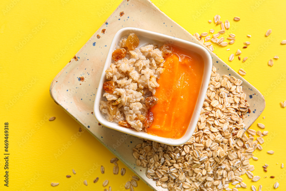 Bowl of tasty oatmeal with pumpkin on yellow background