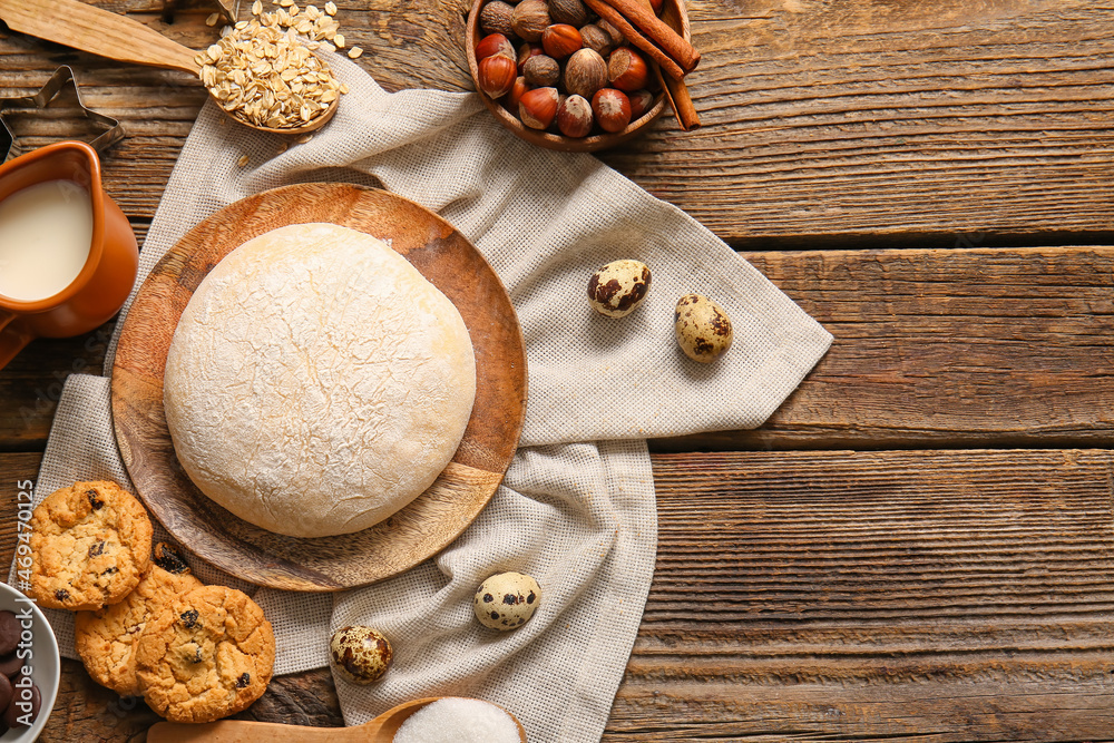 Plate with fresh dough for preparing homemade cookies on wooden background