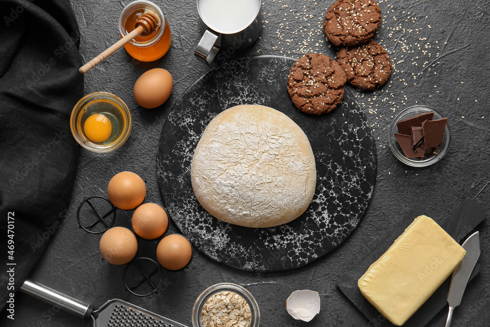 Board with fresh dough for preparing homemade cookies on black background