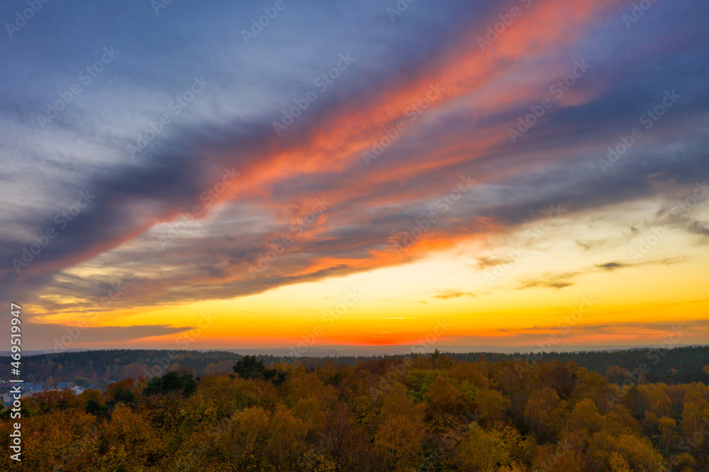 Beautiful sunset over the autumnal forest in Rotmanka, Poland