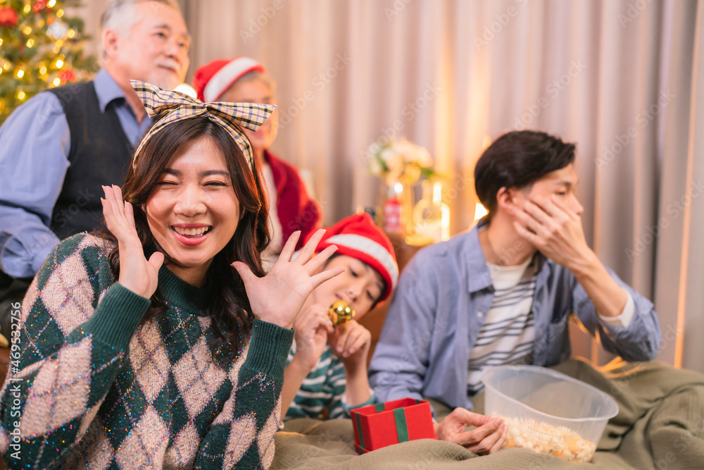 asian adult male give present box to hie parent in christmas holidays while using smartphone talking