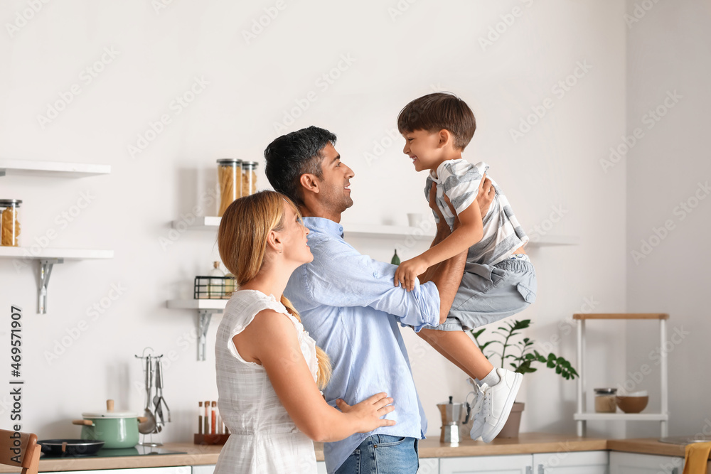 Happy parents with their little son in kitchen