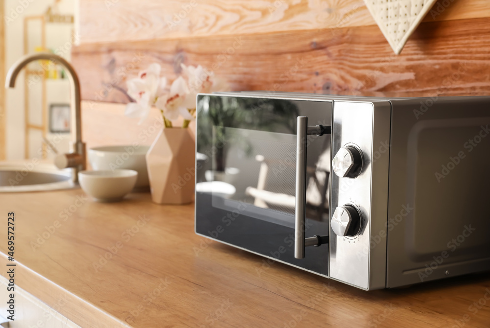 Microwave oven on wooden tabletop in kitchen