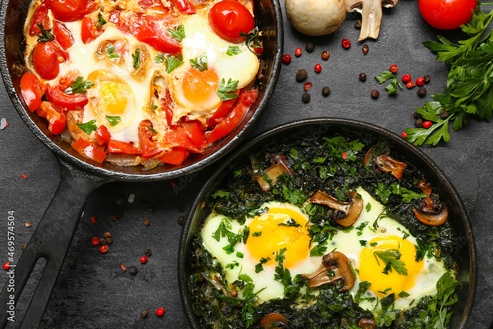 Frying pans with tasty Shakshouka on black background, closeup