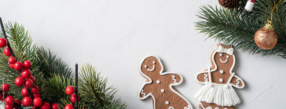 Decorated Christmas gingerbread cookies with decorations on white table background.