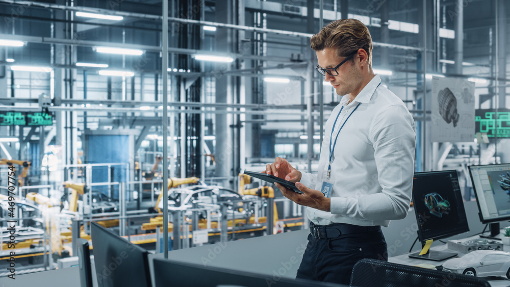 Handsome Engineer in Glasses and White Shirt Using Tablet Computer and Looking Out of the Office at 