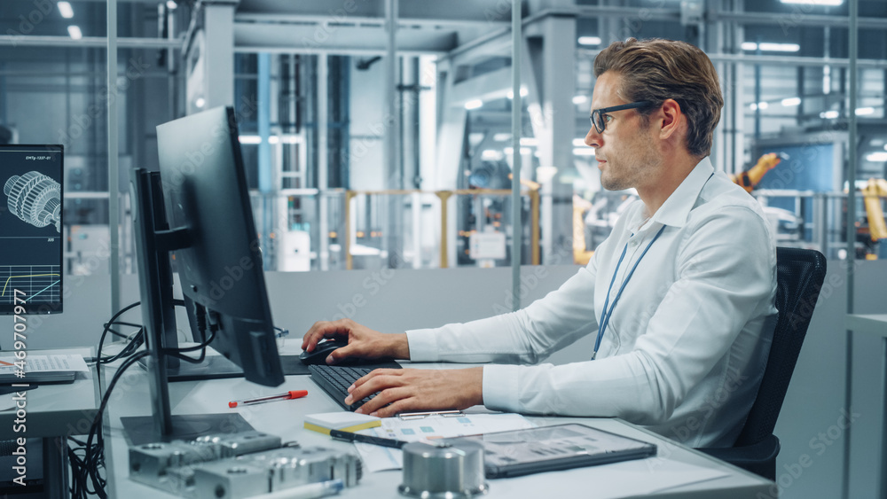 Handsome Automotive Engineer Working on Desktop Computer in Modern Office at Car Assembly Plant. Ind