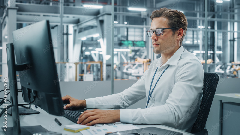 Confident Automotive Engineer Working on Desktop Computer in Modern Office at Car Assembly Plant. In