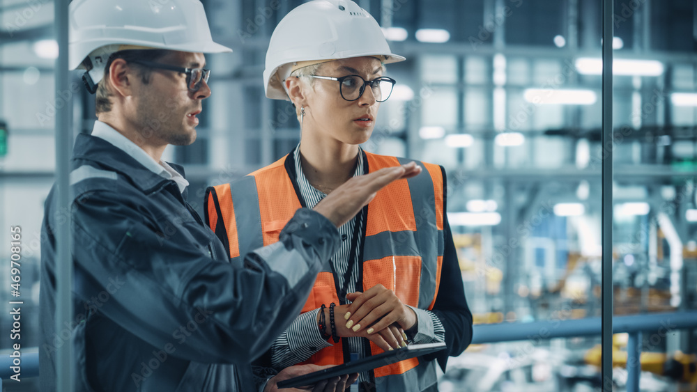 Male Engineer and Female Industrial Product Designer Discuss Work while Using Tablet in Office at a 