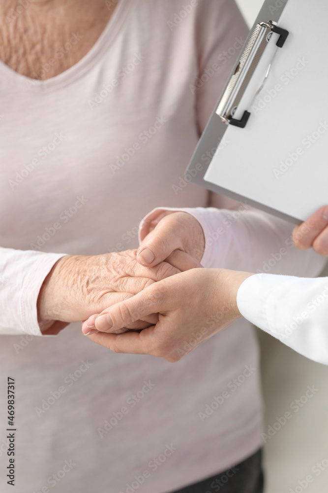 Hands of doctor and elderly woman in clinic