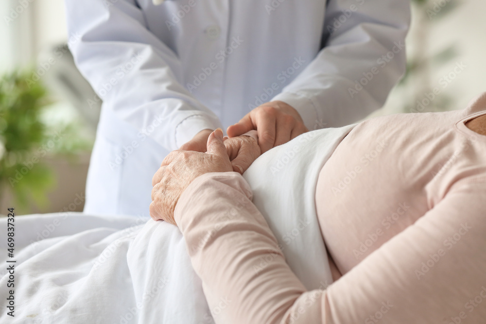 Doctor visiting elderly woman in clinic