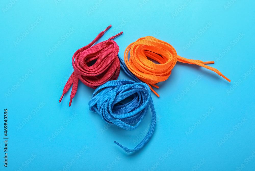 Rolls of shoe laces on color background