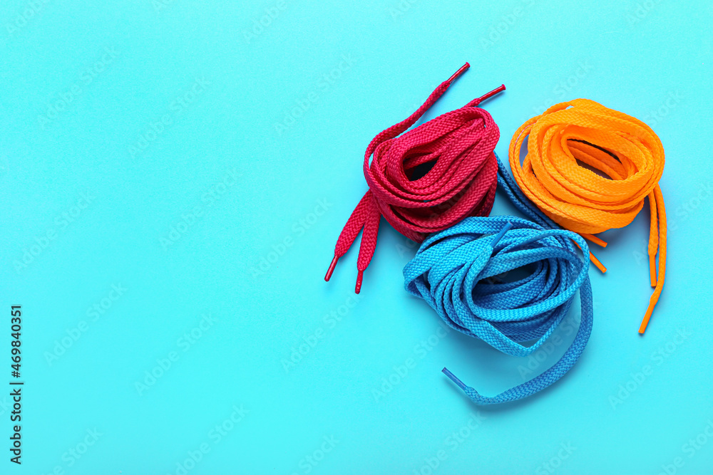 Rolls of shoe laces on color background