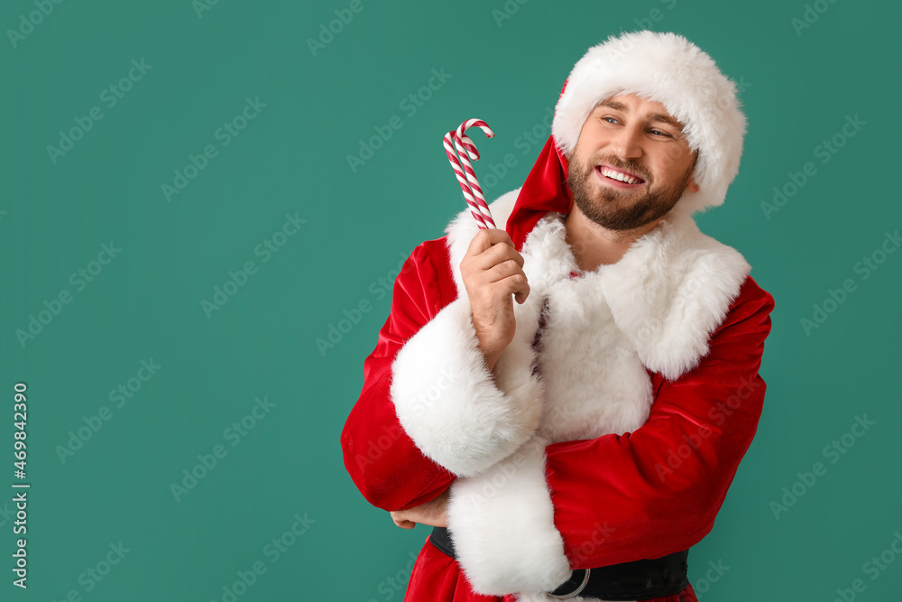 Santa Claus with candy canes on green background