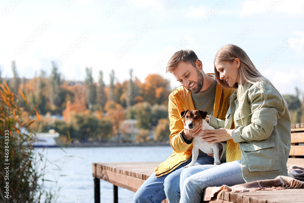 秋天的一天，河边有一对可爱的夫妇和可爱的杰克·拉塞尔梗犬