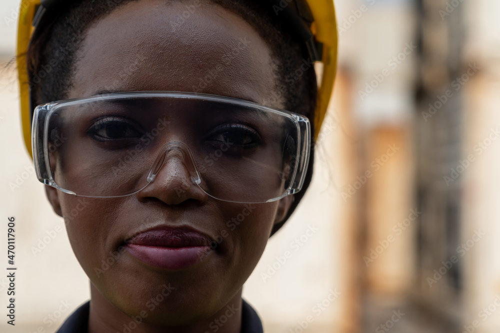 Young African American woman worker at overseas shipping container yard . Logistics supply chain man