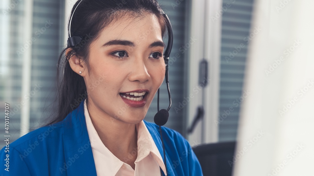 Businesswoman wearing headset working actively in office . Call center, telemarketing, customer supp