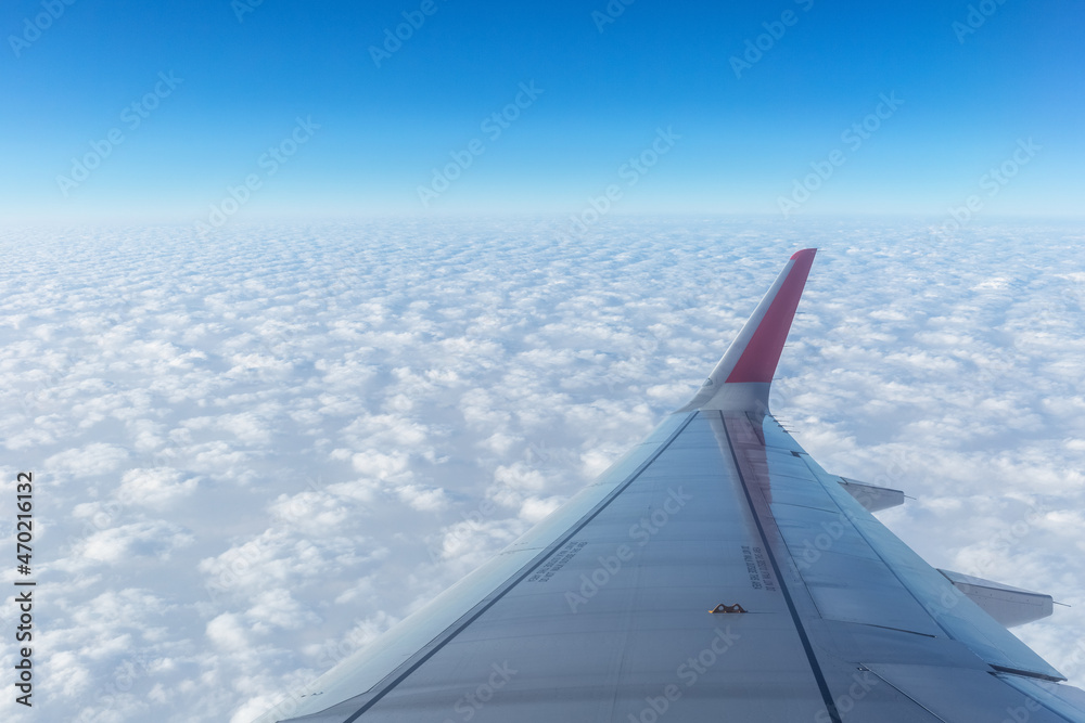 airplane wing above the thick clouds