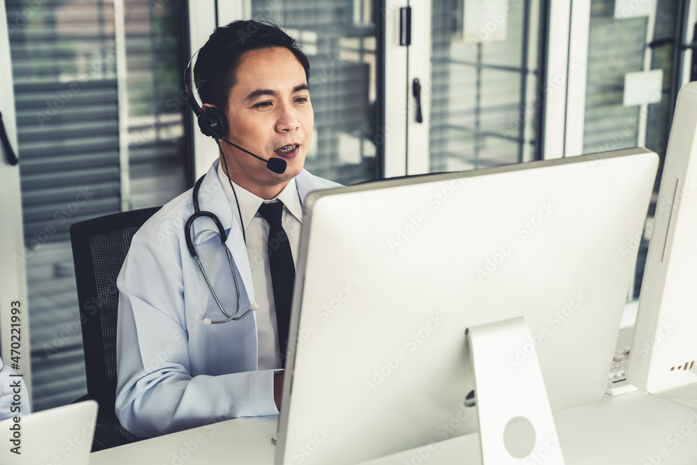 Doctor wearing headset talking actively on video call in a clinic or hospital . Concept of telehealt