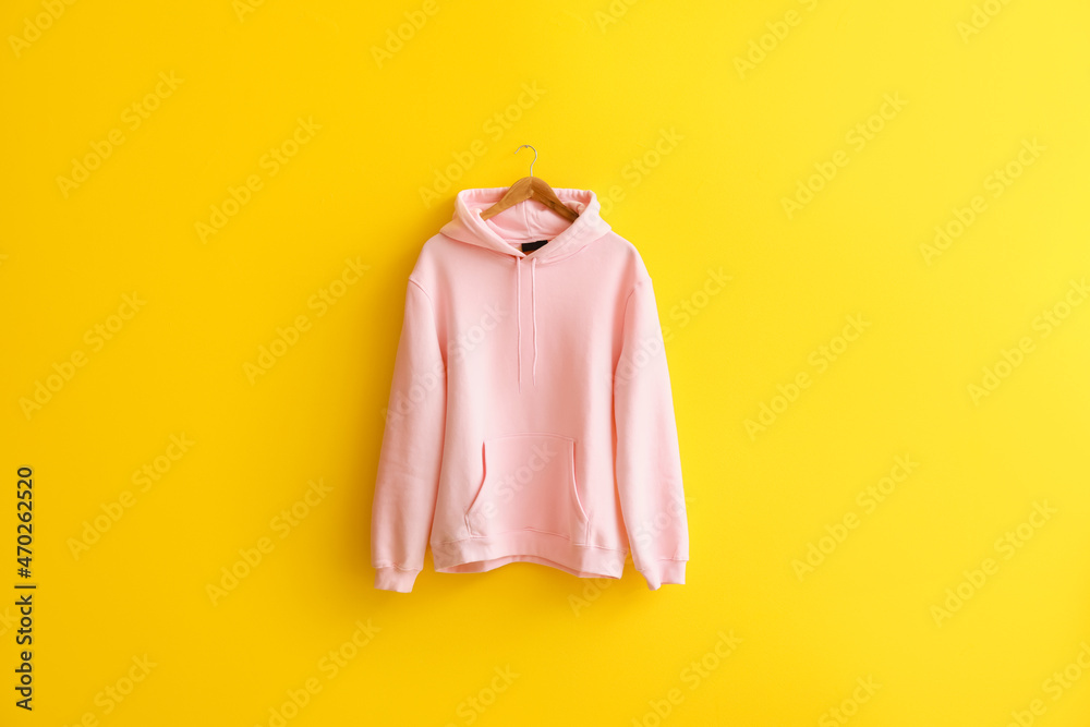 Modern hoodie hanging on color wall