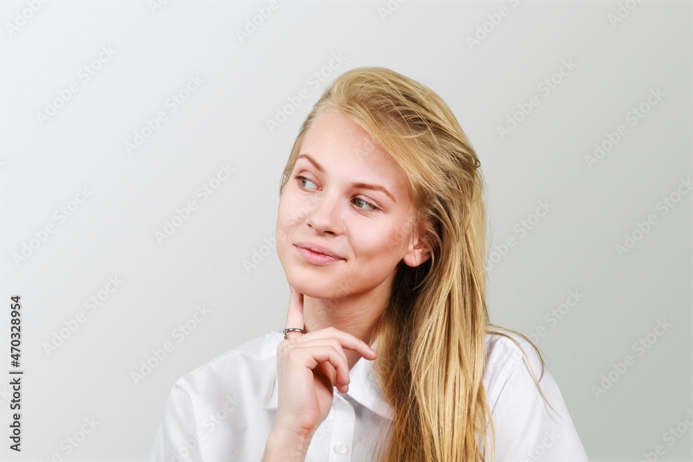 Thoughtful young woman looks aside has dreamy expression interesting